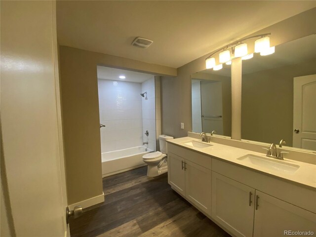 full bathroom with vanity, toilet, tiled shower / bath combo, and hardwood / wood-style flooring