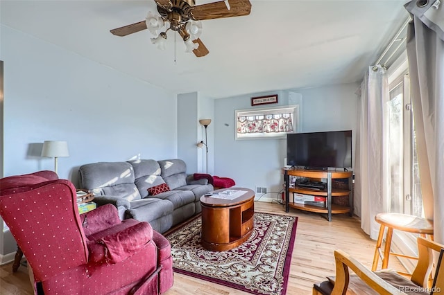 living room with light wood-type flooring and ceiling fan