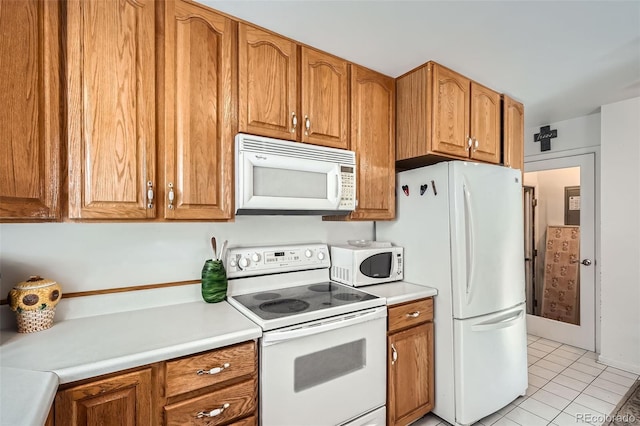 kitchen featuring light tile patterned floors and white appliances