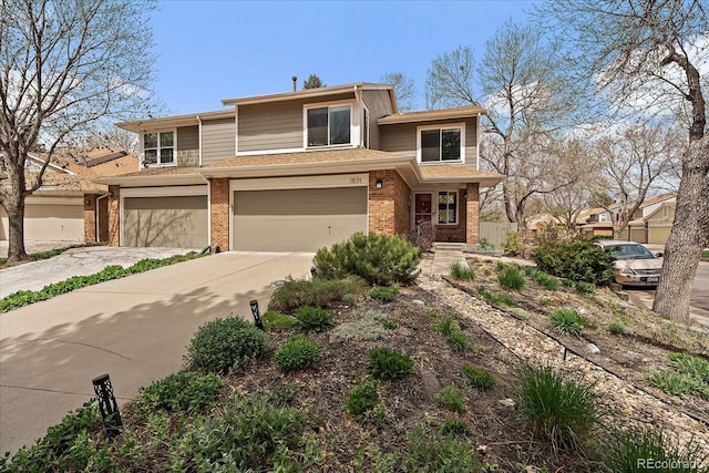 prairie-style house featuring brick siding, an attached garage, and concrete driveway