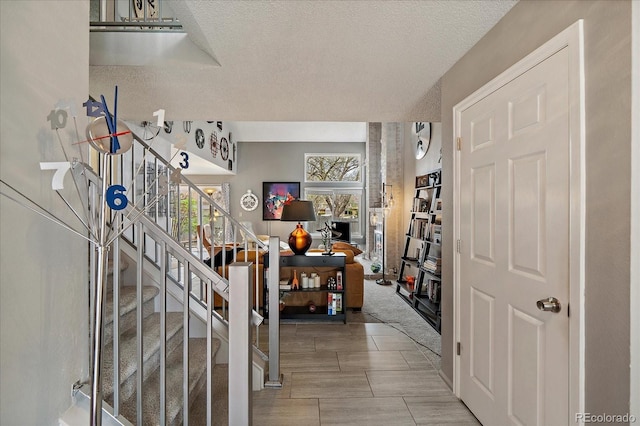 foyer featuring stairs and a textured ceiling