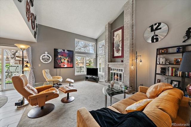 living room with a textured ceiling, high vaulted ceiling, and a fireplace