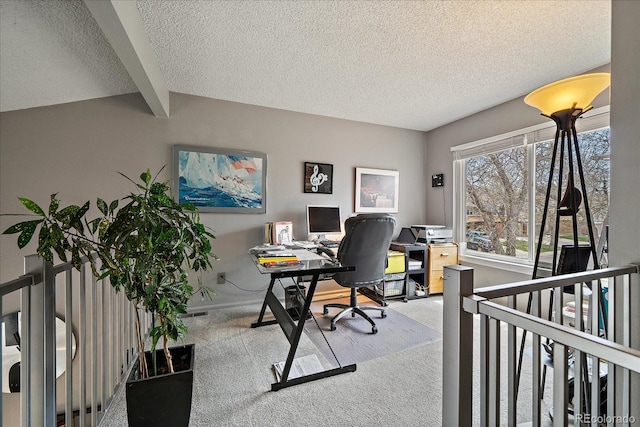 office space with carpet floors, baseboards, beamed ceiling, and a textured ceiling