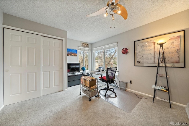 carpeted office space with baseboards, a ceiling fan, and a textured ceiling