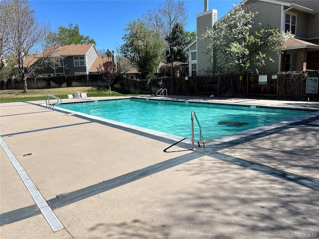 community pool with fence and a patio area