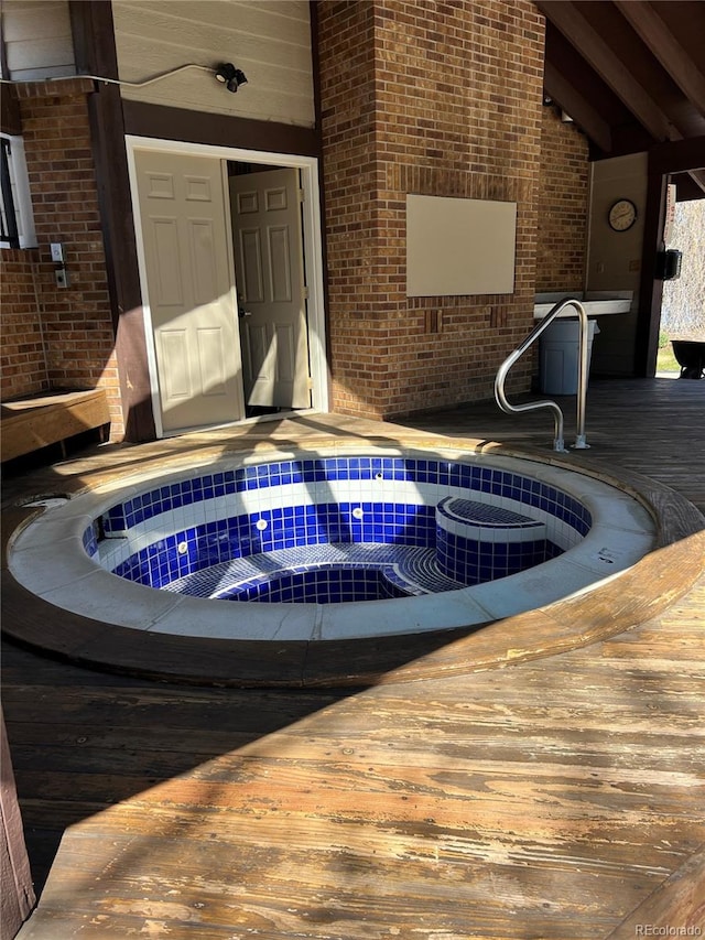 view of swimming pool with an in ground hot tub and a wooden deck