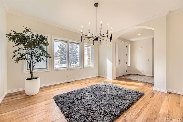 dining area with crown molding, light hardwood / wood-style flooring, and a notable chandelier