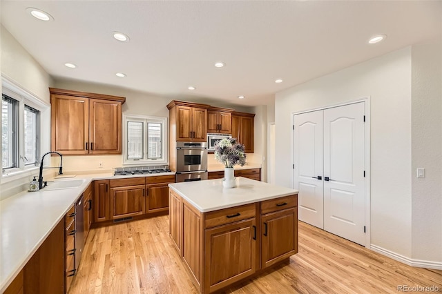 kitchen featuring light hardwood / wood-style floors, a center island, sink, and a wealth of natural light