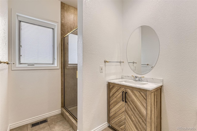 bathroom featuring vanity, tile patterned floors, and a shower with shower door