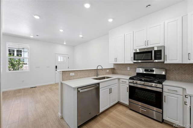 17123 W 91st Ln, Arvada, CO 80007 - kitchen featuring appliances with stainless steel finishes, backsplash, a peninsula, light countertops, and white cabinets