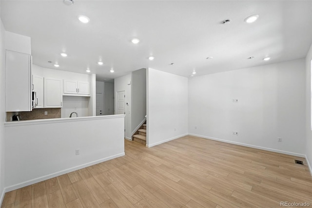 17123 W 91st Ln, Arvada, CO 80007 - unfurnished living room with recessed lighting, light wood-style flooring, and stairs
