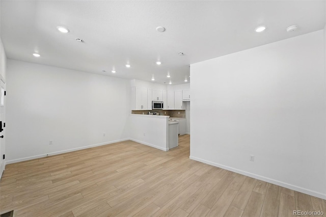 17123 W 91st Ln, Arvada, CO 80007 - unfurnished living room with recessed lighting and light wood-style flooring