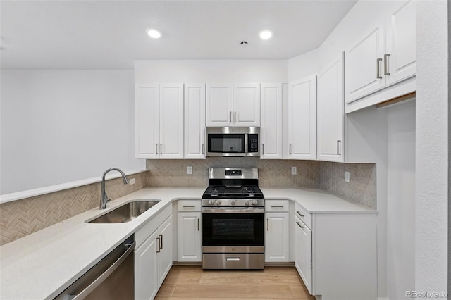 17123 W 91st Ln, Arvada, CO 80007 - kitchen with appliances with stainless steel finishes, white cabinets, light countertops, backsplash, and recessed lighting