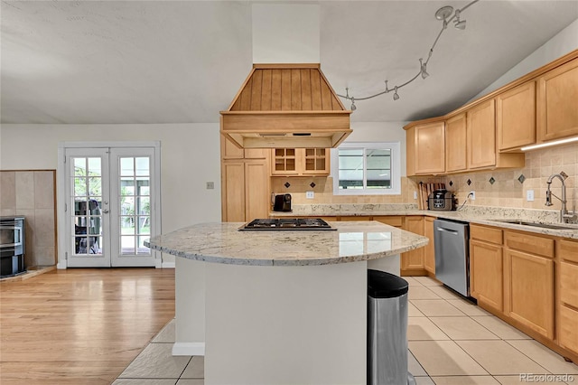 5722 W Chestnut Ave, Littleton, CO 80128 - kitchen with stainless steel appliances, light brown cabinets, a center island, light stone counters, and french doors