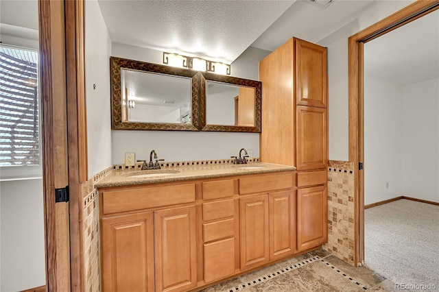 5722 W Chestnut Ave, Littleton, CO 80128 - full bath featuring double vanity, plenty of natural light, a textured ceiling, and tile patterned flooring