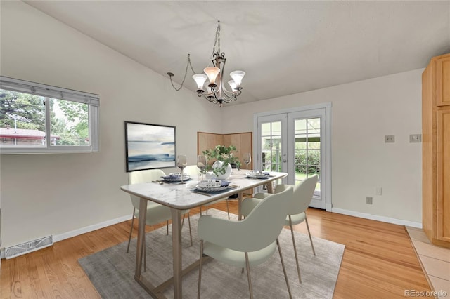5722 W Chestnut Ave, Littleton, CO 80128 - dining space featuring a chandelier, french doors, healthy amount of natural light, light wood-type flooring, and vaulted ceiling