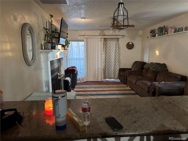 living room featuring ceiling fan and a textured ceiling