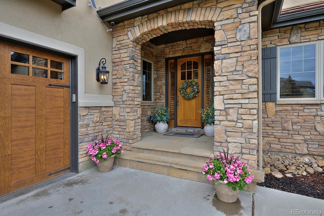 14370 Osage St, Westminster, CO 80023 - view of exterior entry with stone siding, stucco siding, and a porch