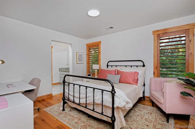 14370 Osage St, Westminster, CO 80023 - bedroom featuring wood finished floors, baseboards, and connected bathroom