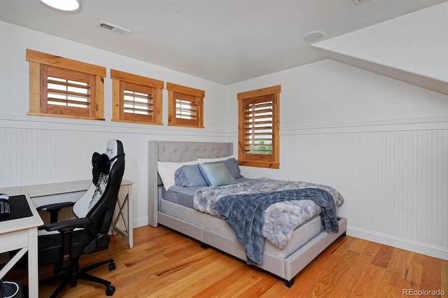 14370 Osage St, Westminster, CO 80023 - bedroom featuring light wood finished floors, an office area, lofted ceiling, and a wainscoted wall