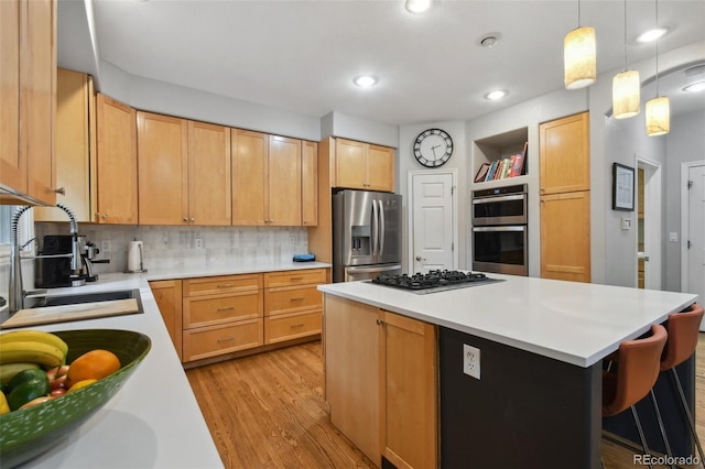 kitchen featuring light wood-type flooring, a kitchen island, stainless steel appliances, and light countertops