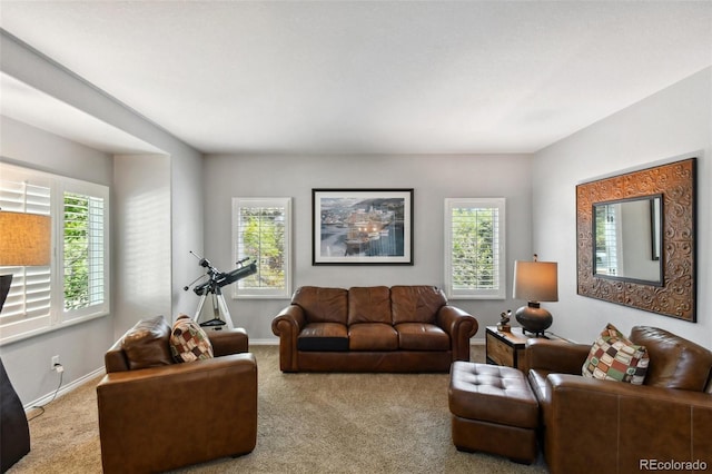 carpeted living area featuring baseboards