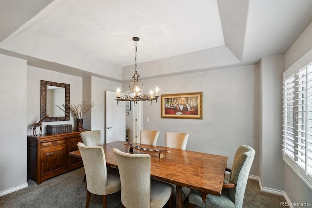 carpeted dining area with plenty of natural light, baseboards, a raised ceiling, and a notable chandelier