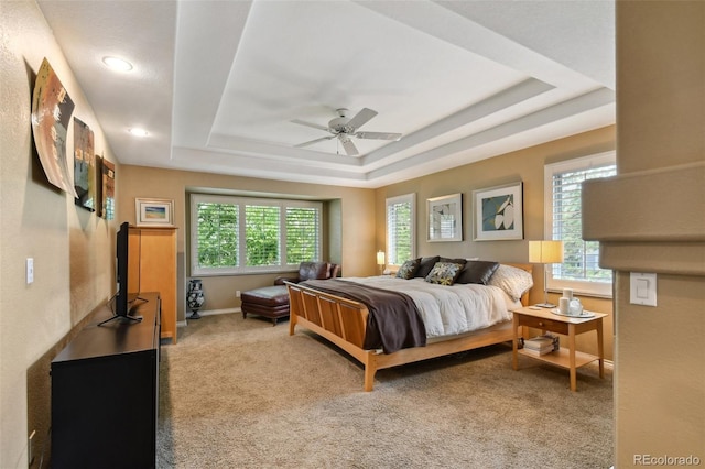 bedroom featuring a ceiling fan, a raised ceiling, carpet flooring, and baseboards