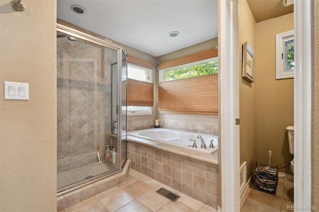 bathroom with toilet, tile patterned flooring, a shower stall, and a bath