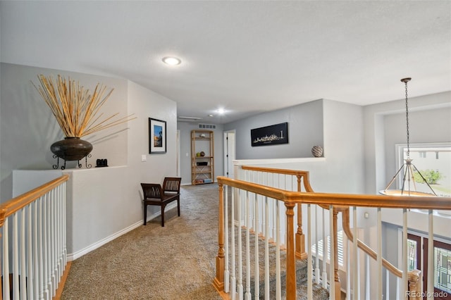 hall with visible vents, baseboards, an upstairs landing, carpet floors, and recessed lighting