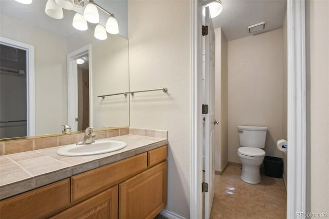 bathroom featuring tile patterned flooring, toilet, visible vents, vanity, and baseboards