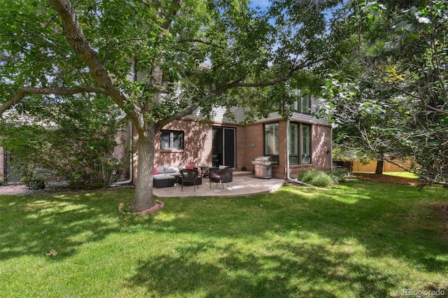 back of house with a yard, outdoor lounge area, a patio area, and brick siding