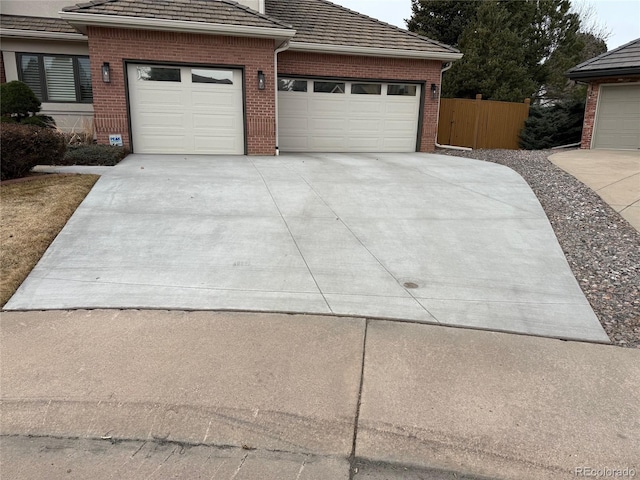 exterior space with concrete driveway and fence