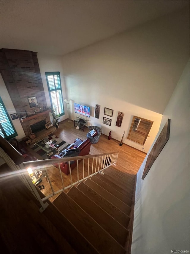 living area featuring wood finished floors, a fireplace, and stairway