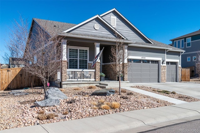 view of front facade featuring an attached garage, fence, covered porch, and driveway