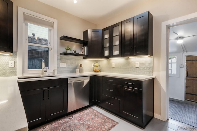 bar with light tile patterned floors, decorative backsplash, a sink, and dishwasher