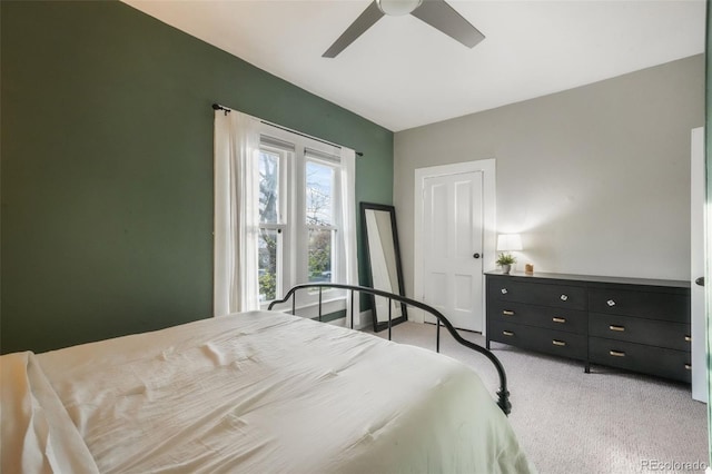 bedroom with a ceiling fan and light colored carpet