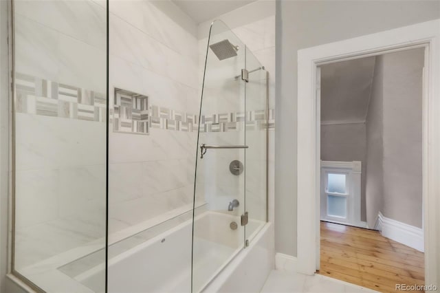 bathroom with baseboards, tub / shower combination, and wood finished floors