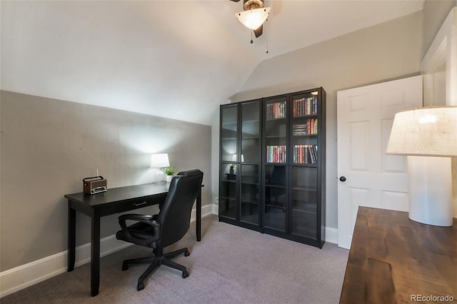 carpeted home office with a ceiling fan and vaulted ceiling