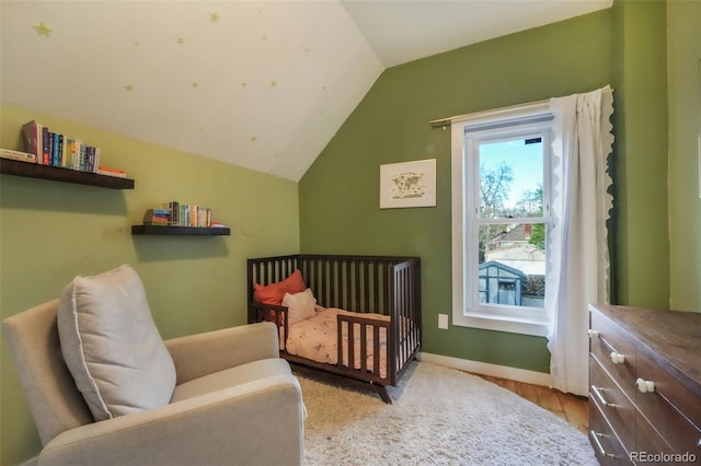 bedroom featuring baseboards and lofted ceiling