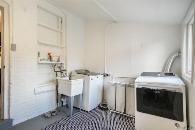 clothes washing area with laundry area, a sink, and washing machine and clothes dryer