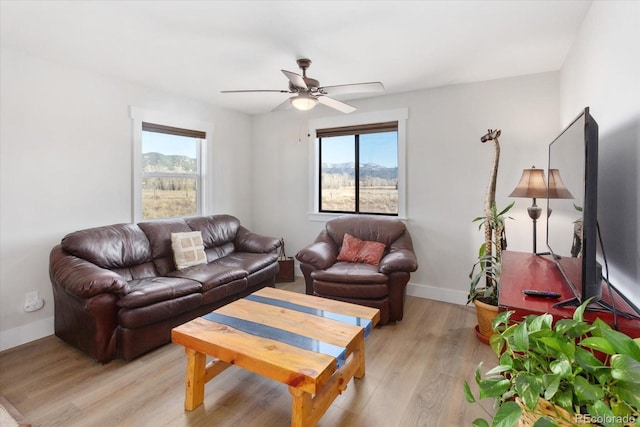 living room with a wealth of natural light, ceiling fan, and light hardwood / wood-style flooring