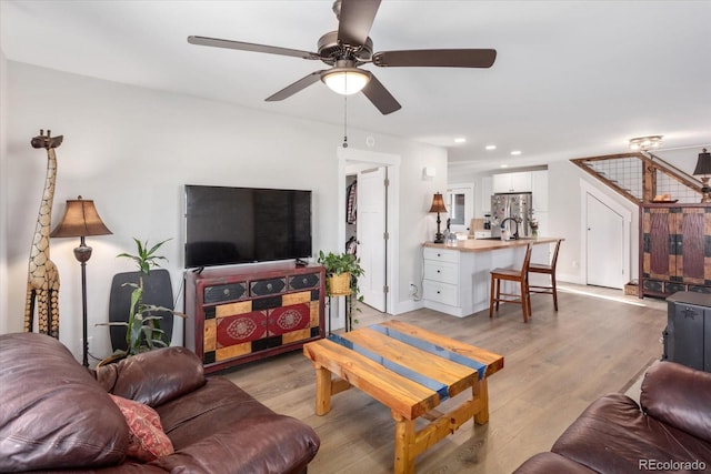 living room with light hardwood / wood-style flooring and ceiling fan