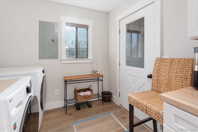 laundry room with separate washer and dryer, electric panel, and light hardwood / wood-style floors