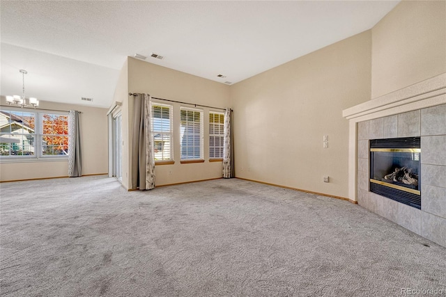 unfurnished living room featuring lofted ceiling, carpet floors, a chandelier, and a fireplace