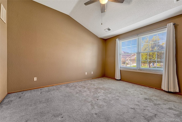 empty room with ceiling fan, a textured ceiling, lofted ceiling, and light colored carpet