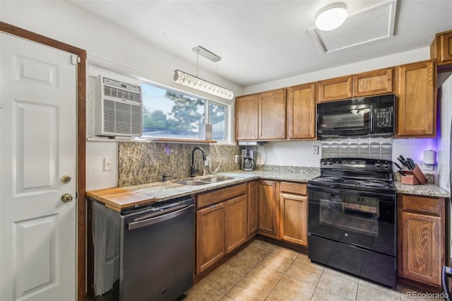 kitchen featuring backsplash, black appliances, sink, light tile patterned floors, and decorative light fixtures