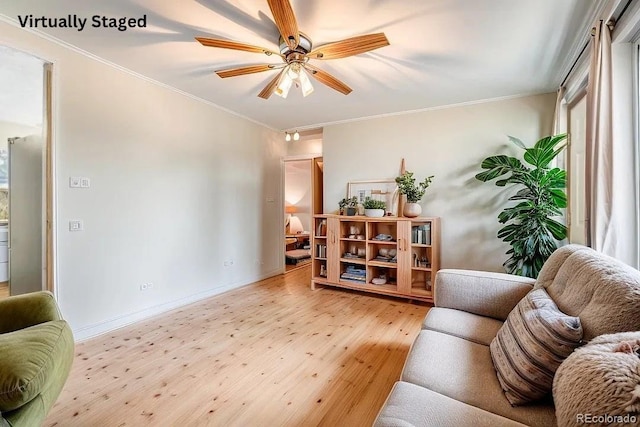 living room with ceiling fan, crown molding, and light hardwood / wood-style flooring