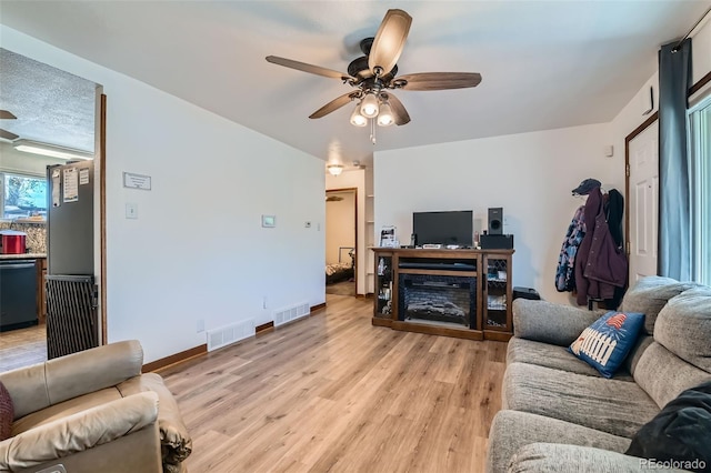 7940 Pontiac St, Commerce City, CO 80022 - living room featuring light wood-style flooring, visible vents, a ceiling fan, and baseboards