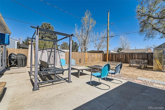 7940 Pontiac St, Commerce City, CO 80022 - view of patio / terrace featuring a fire pit, an outbuilding, a fenced backyard, and a storage shed